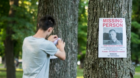 A Missing Persons poster being put up