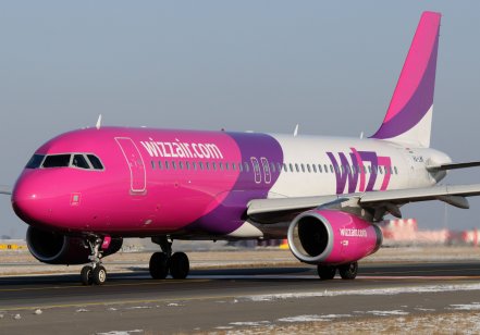Pink, purple and white Wizz Air airbus on a runway