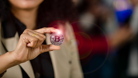 Photo of woman holding a coin