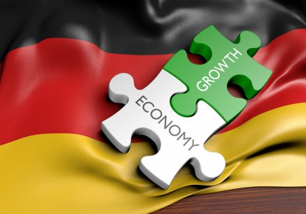 Growth and economy jigsaw pieces lying on a German flag