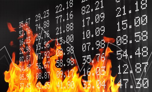 Market ticker board in flames indicating market prices during a recession