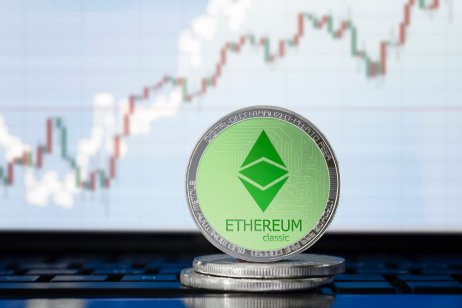 Ethereum Classic (ETC) coins with price chart behind them
