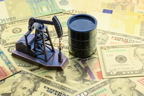 Oil, petrodollar and crude oil concept: jack pump and a black barrel on US dollar banknotes