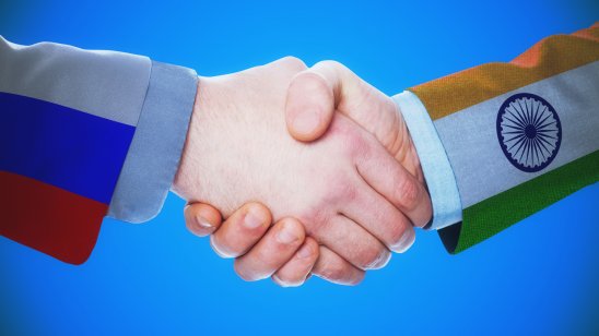 Image showing a handshake between a Russian flag-suited man and an Indian flag-suited man