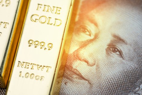 Shiny gold bullion ingot on a Chinese yuan banknote