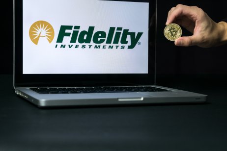 Bitcoin coin with the Fidelity logo on a laptop screen