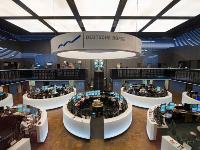 Traders engage in trade at their desks inside the Frankfurt Stock Exchange 
