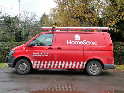 A red HomeServe delivery van on the road