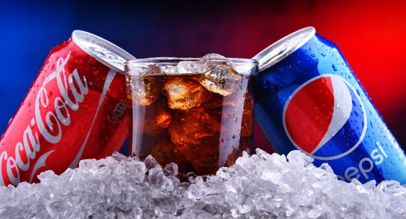 Two cans of world's most popular soft drinks: Coca Cola and Pepsi with crushed ice