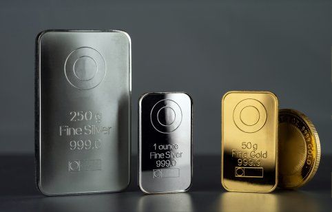 Gold and silver bars standing in a row against a grey background