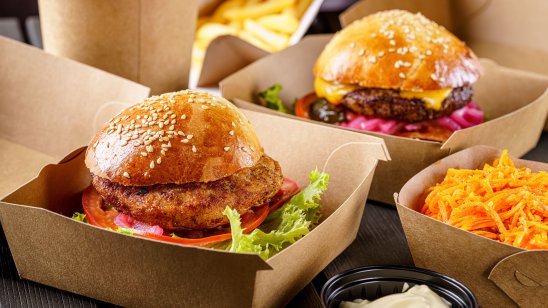 A picture of street food. Meat cutlet burgers in paper boxes. Food delivery. 
