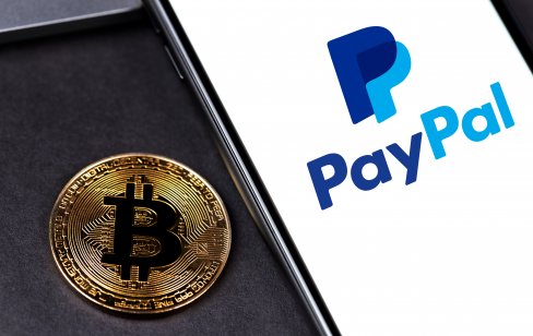 Paypal logo in a smartphone, next to a bitcoin symbol 