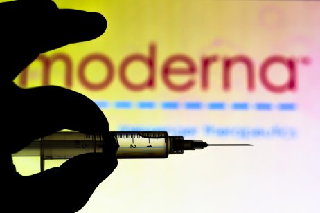 Medical syringe set against Moderna Therapeutics company logo 