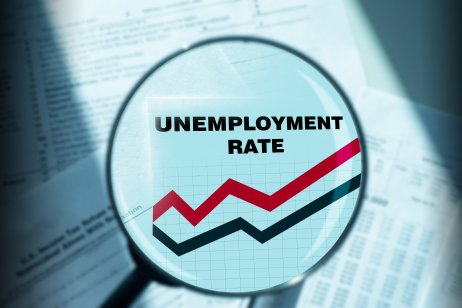 Unemployment rate graph is increasing. Inscription unemployment rate under a magnifying glass. 