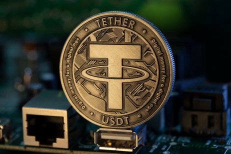 Tether USDT cryptocurrency physical coin placed on microscheme in the dark background. Selective focus.