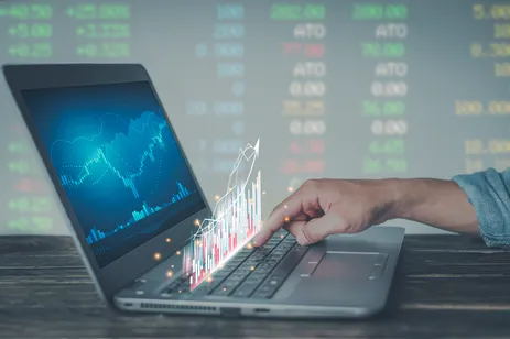 Young money businessman sitting staring at a computer screen displaying a crypto currency featuring stock tickers or graphs. Stock trading platform concept. professional financial advisor.