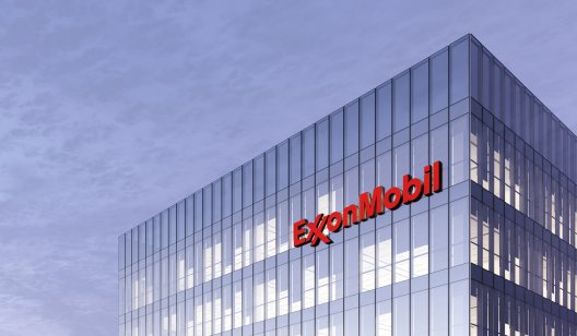 Exxon Mobil stock forecast: Will energy giant rebound to record high? ExxonMobil Signage Logo on Top of Glass Building. Workplace of Gas and Oil Company in High-rise Office Headquarter.