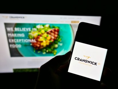 Person holding a smartphone with the logo of British food producing company Cranswick on the screen 