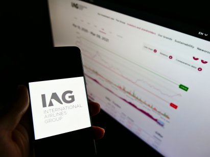 Stuttgart, Germany - 03-10-2021: Person holding smartphone with logo of airline company International Airlines Group (IAG) on screen in front of website. Focus on phone display. Unmodified photo.