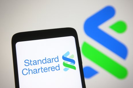  In this photo illustration Standard Chartered plc logo of a British multinational banking and financial services company is seen on a mobile phone screen.