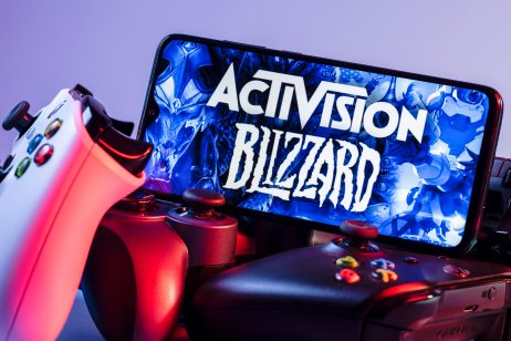 Smartphone with Activision Blizzard logo on the screen on top of game consoles