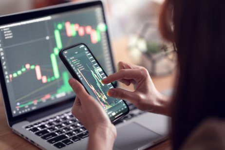 How to invest in cryptocurrency in India: A step-by-step guide. Closeup - Woman is checking Bitcoin price chart on digital exchange on smartphone, cryptocurrency future price action prediction.