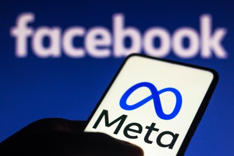 Meta logo on a mobile screen with a Facebook background