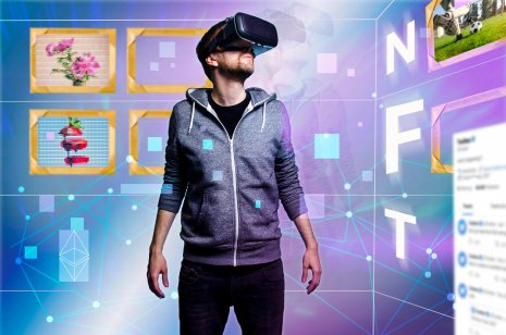 Image of standing man with a virtual reality camera on his eyes and with NFT written vertically 