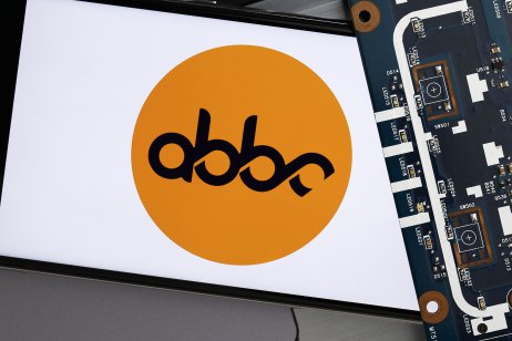 The abbc coin’s logo on smartphone next to a circuit board