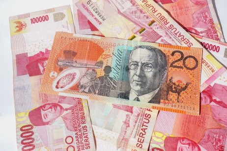 Australian 20-dollar banknote on top of Indonesian 100,000-rupiah banknotes 