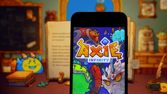 Axie Infinity logo on smartphone with game background