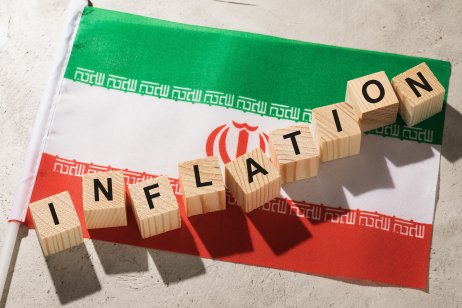 Flag of Iran and wooden cubes with text, a concept on the theme of inflation in the country