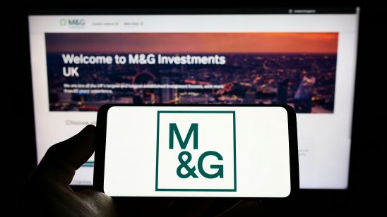 A image of Person holding smartphone with logo of British investment company M&G plc (MG) 