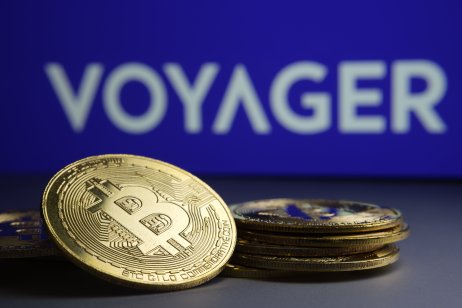 The Voyager company name appears behind a pile of cryptocurrencies