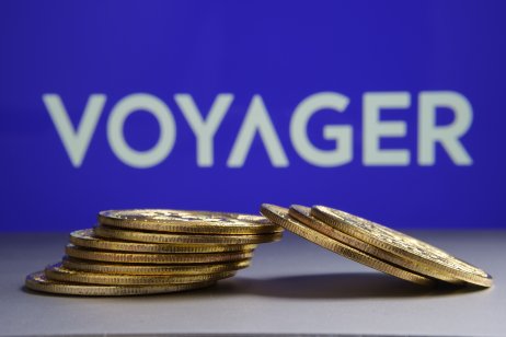 Voyager coins are lying flat. Voyager logo in the background.