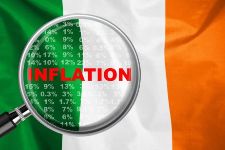 Magnifying glass focused on the word inflation on Ireland flag background