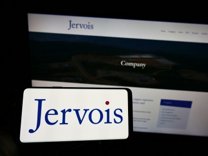 Person holding cellphone with logo of Australian company Jervois Mining Ltd. on screen in front of business webpage.