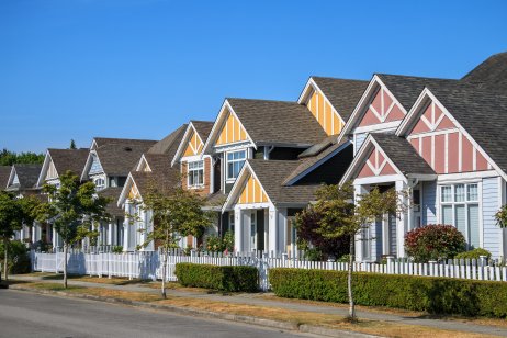  row of houses showing front yards of the houses and streets with trees and bushes in Richmond, British Columbia, Canada.