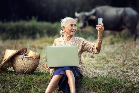  Elderly Vietnamese woman using a laptop and smartphone 