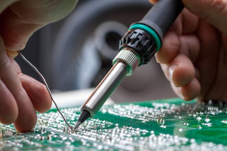 Soldering iron putting electronic parts in place