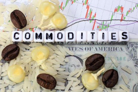 Coffee beans, rice, corn and a letter cube on the background of a dollar and a candle. The conceptual image of commodity trade.