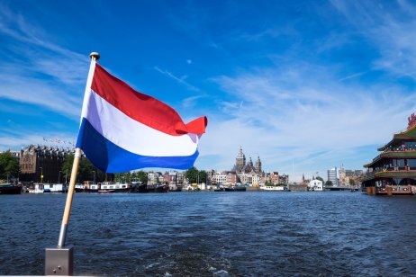 flag of the Netherlands on the background of the river in Amsterdam