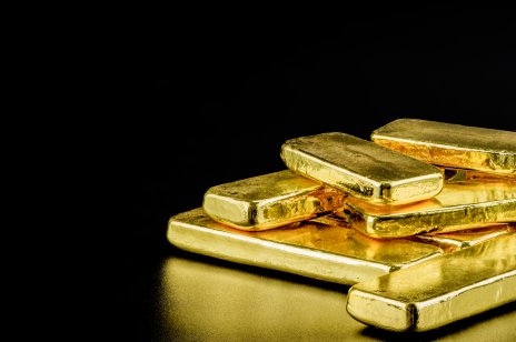 Gold bars scattered on a black background 