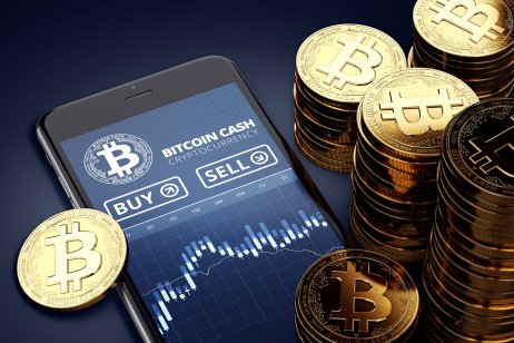 Bitcoin cash tokens next to a smartphone with trading bitcoin cash