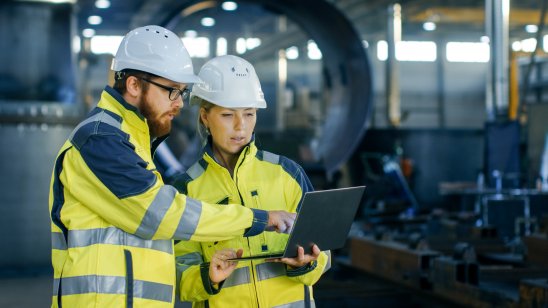 Industrial engineers in hard hats discuss project