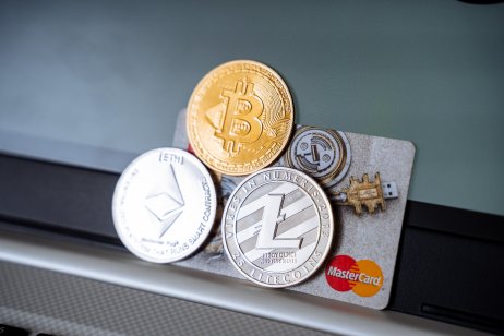 Cryptocurrency coins on a MasterCard credit card.