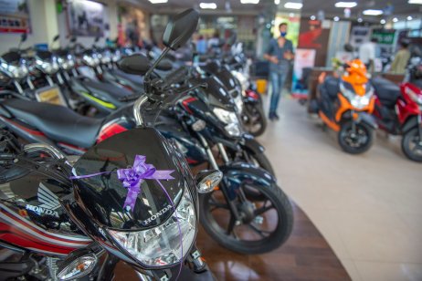 A variety of scooters and motorcycles for sale at a Honda dealership showroom in Uttar Pradesh, India