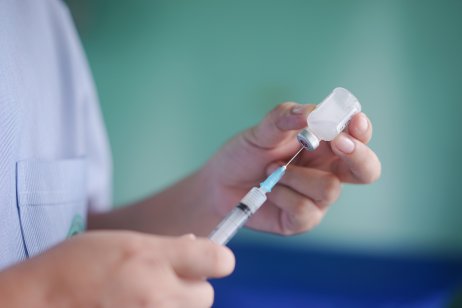 Doctor prepares a syringe to administer the vaccine