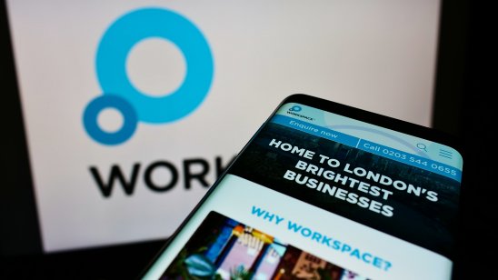 A mobile phone with webpage of British property company Workspace Group on screen in front of business logo 