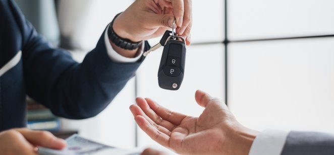 A car dealer hands over a set of vehicle keys